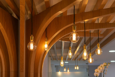 Low angle view of illuminated chandelier hanging in building