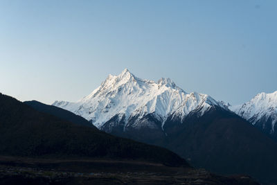 Scenic view of snowcapped mountains against clear sky