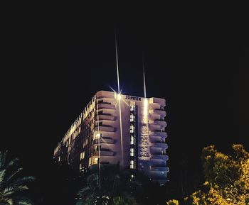 Low angle view of illuminated building against sky at night