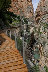 Footbridge over rocks against mountains