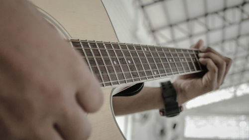 Midsection of man playing guitar