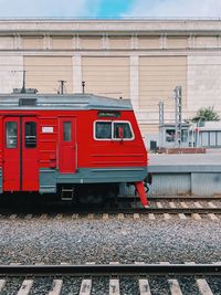 Train on railroad tracks by building