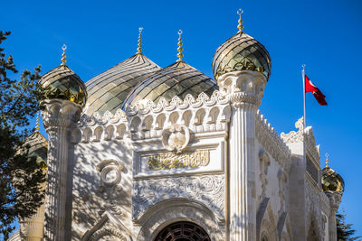 Low angle view of flags on building against sky