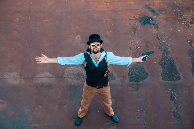 Portrait of young man standing against wall