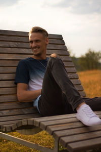 Portrait of young man sitting on bench