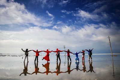 People standing on beach against sky