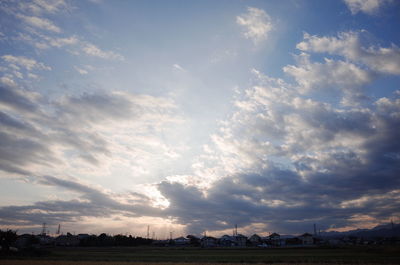 Scenic view of field against cloudy sky