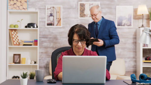 Portrait of young woman using laptop at home