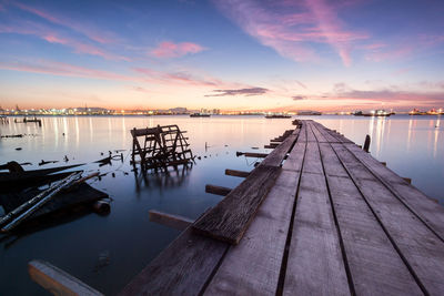 Pier over sea against sky at sunset