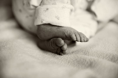 Close-up of baby foot on bed