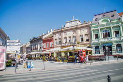 People on street against buildings in city