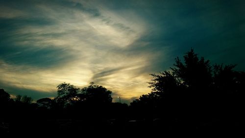 Silhouette trees against sky at sunset