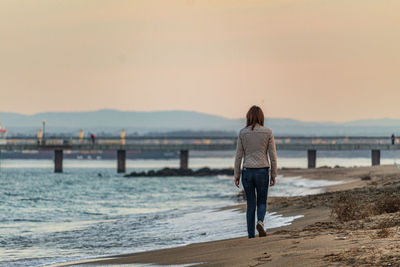 Rear view of woman standing on beach