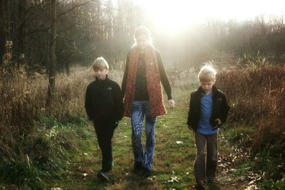 Mother walking with boys in forest