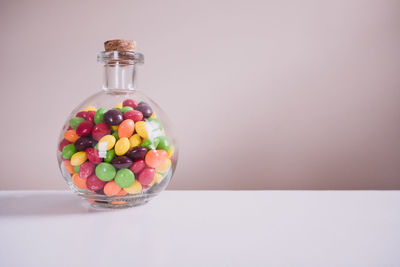 Multi colored candies in bottle over white background