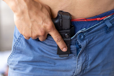 Midsection of man holding camera