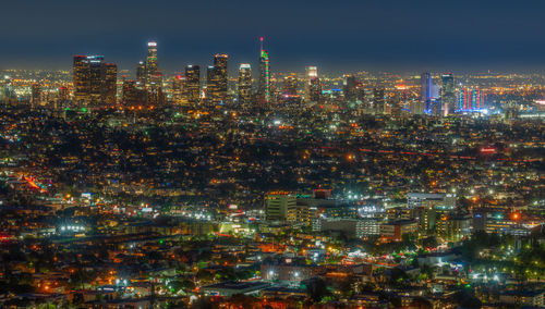 Illuminated cityscape against sky at night