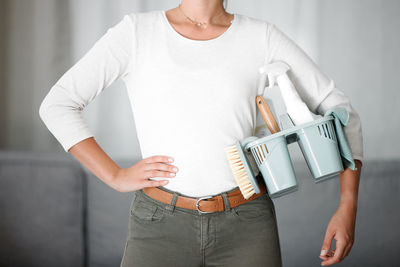 Midsection of young woman holding book