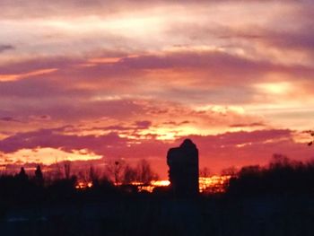 Silhouette buildings against sky during sunset