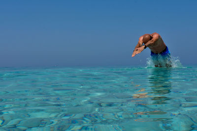 Side view of shirtless man diving in sea