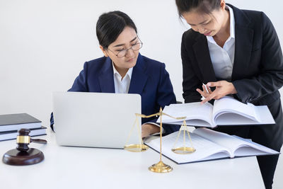 Female lawyers reading book at table in courtroom