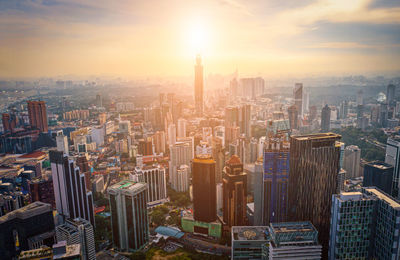 Aerial view of buildings in city during sunset