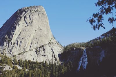 Panoramic view of rocky mountains against clear blue sky