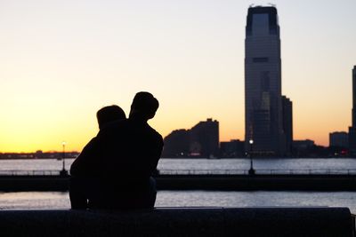 Silhouette of people standing at sunset