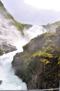 Scenic view of waterfall against sky