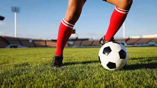 Low section of man playing soccer at stadium