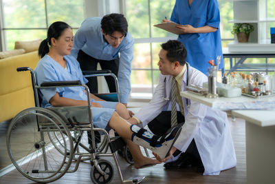 Rear view of man using mobile phone while sitting on wheelchair