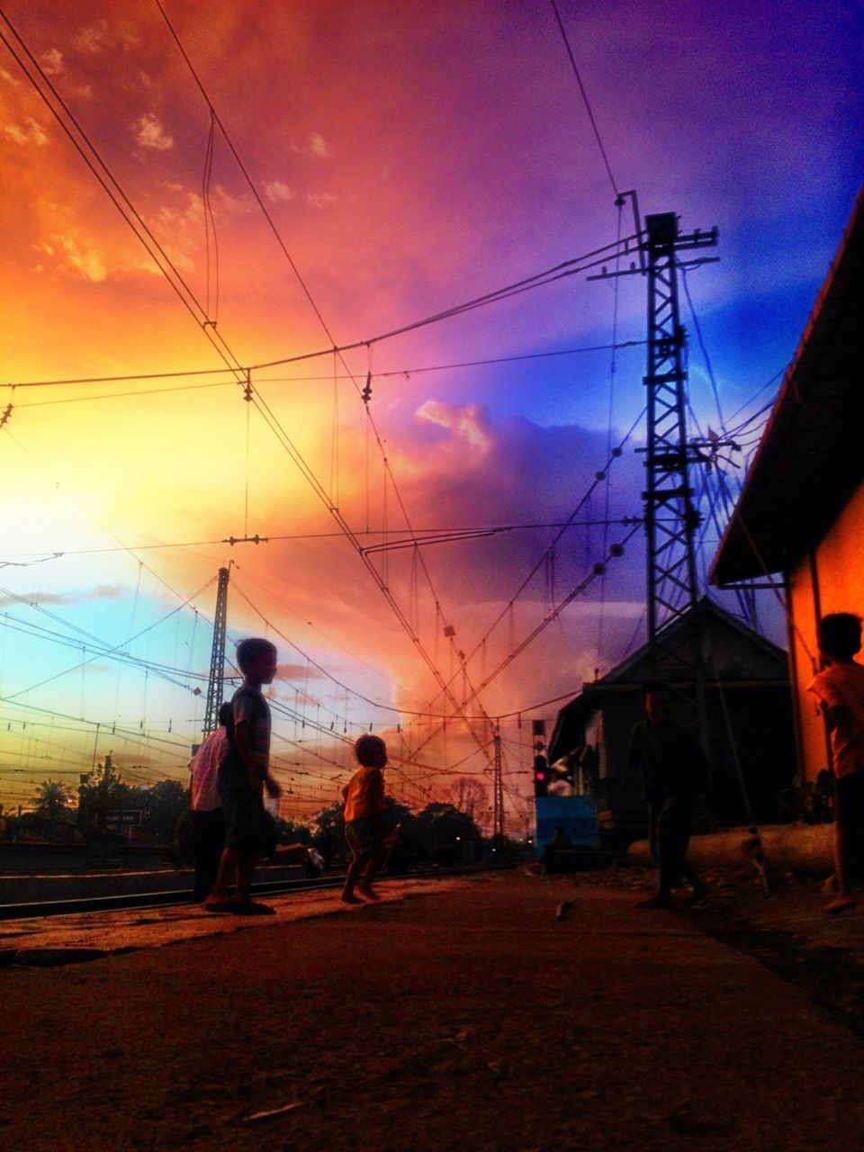 power line, sky, men, electricity pylon, cable, built structure, architecture, building exterior, lifestyles, sunset, power supply, leisure activity, full length, person, rear view, walking, connection, electricity