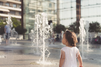 Girl standing by fountain