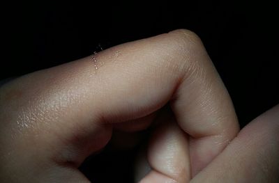 Close-up of hands against black background