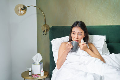 Young woman using mobile phone at home