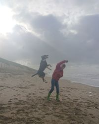 Full length of friends walking on sand at beach