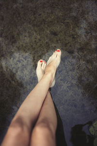 Low section of woman legs over lake