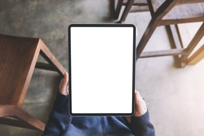 Low section of person holding smart phone on table