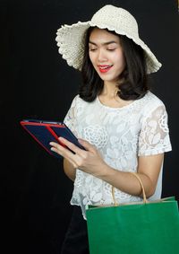 Young woman using mobile phone while standing on camera