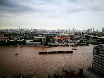 View of cityscape against cloudy sky