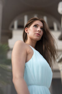 Portrait of young woman looking away while standing in gym