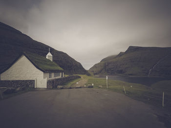 Built structure on road by mountain against sky