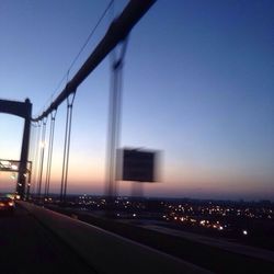 Illuminated bridge against sky at sunset