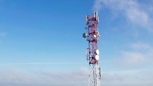 Low angle view of communications tower against blue sky