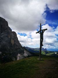 Cross on land against sky