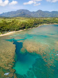 Scenic view of sea and mountains against sky