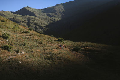 People riding motorcycle on mountain against sky