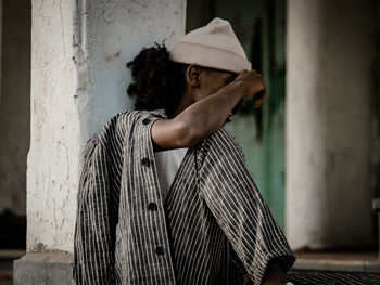 Portrait of man standing against wall