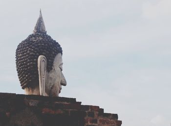 Low angle view of statue of historic building against sky
