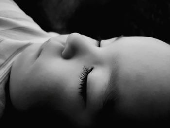 Close-up of baby over black background